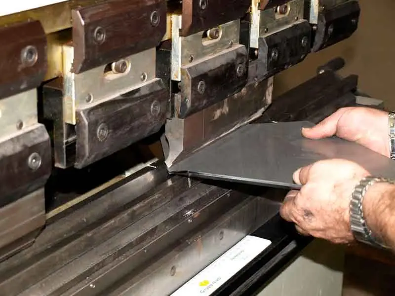 Operario plegando una chapa en la plegadora CNC
